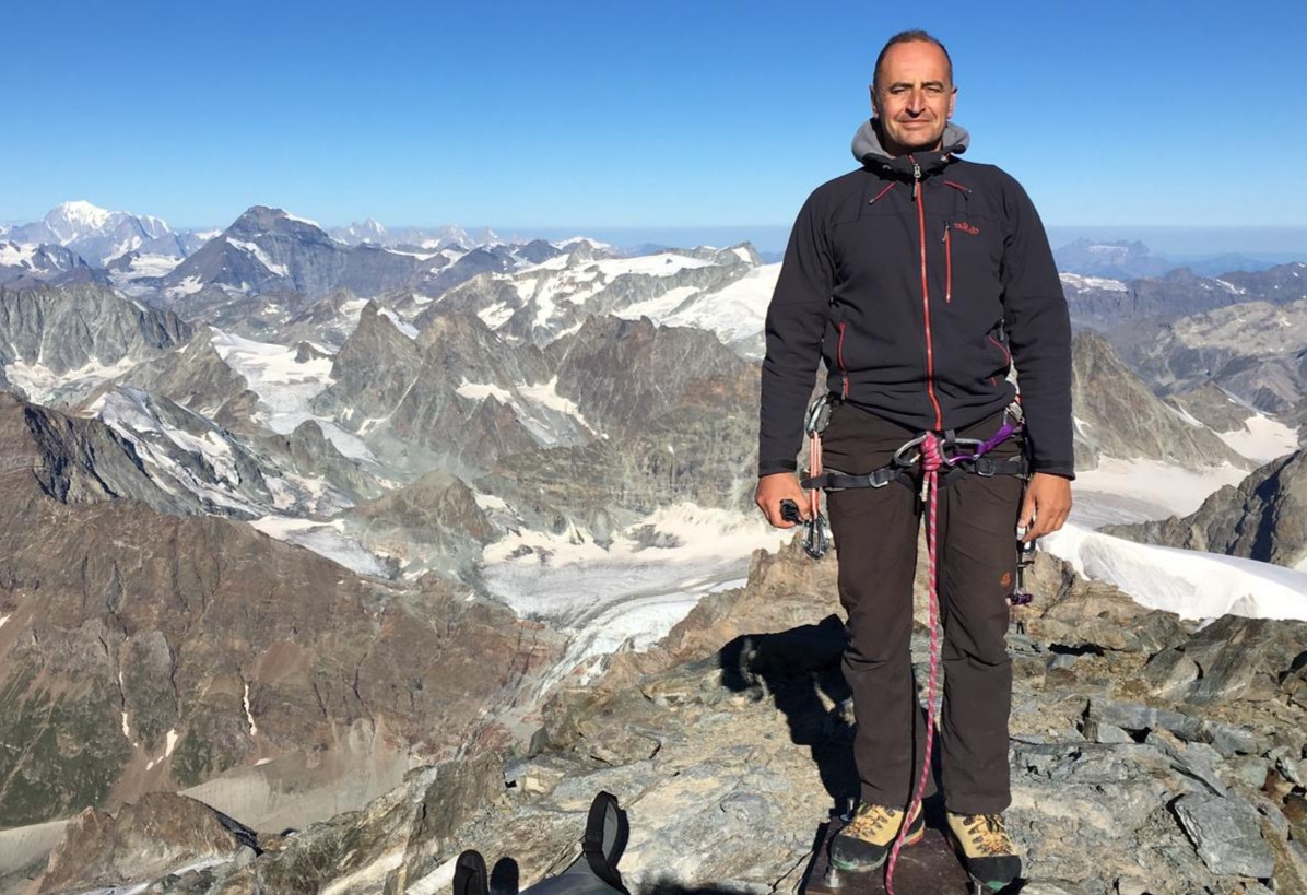 On the summit of Dent d'Herens (4,174m), Pennine Alps. Mont Blanc (4,809m) back, far left.